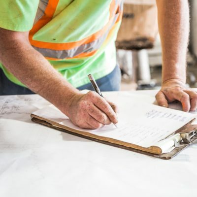 person-writing-on-paper-on-top-of-table